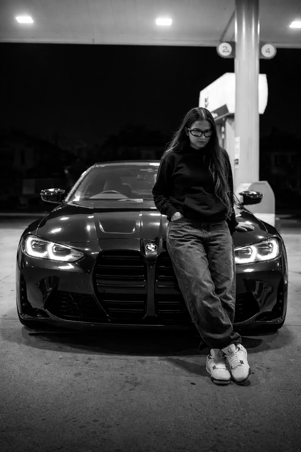 Мужчина у чёрного BMW M4 Competition на АЗС ночью